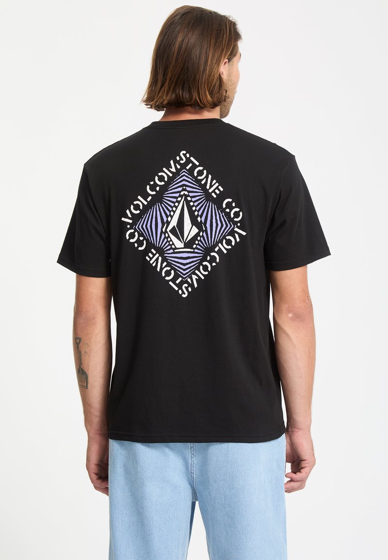 Zwarte katoenen t-shirt met een geometrische grafiek in wit en paars op de achterkant. Heeft een losse pasvorm en een ronde halslijn.