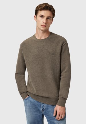 Olivgrüner Pullover aus einem strukturierten Strickstoff. Mit Rundhalsausschnitt und gerippten Bündchen sowie Saum. Kleines Logo auf der Brust.