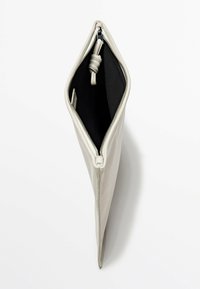 Borsa a mano in pelle di un beige chiaro, caratterizzata da un design allungato, chiusura con zip argentata e una texture liscia. Fodera interna nera.