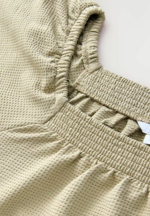 Bežna kratka majica z zakrčenimi rokavi, teksturirano blago, z nabranim izrezom in elastičnim pasom. Ima vzorec mreže in mehak, raztegljiv material.