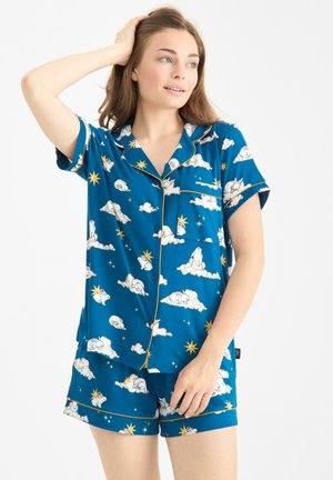 Ensemble de pyjama bleu comprenant des manches courtes, un col à revers et une poche. Le motif présente des nuages, des étoiles et des lapins endormis, avec des accents en doré.