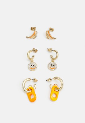Quatro pares de brincos: metal dourado, com acabamentos laranja, um com strass, um que apresenta um charme de sorriso laranja, e outro com um elos de plástico laranja.