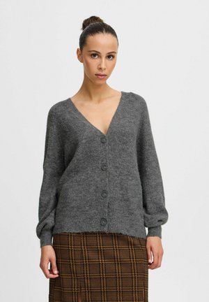 Gray wool cardigan with a V-neck, long sleeves, and six dark buttons. The texture is soft and cozy, paired with a brown plaid skirt.