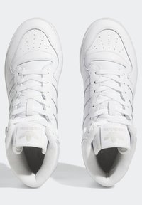 Ein Paar weiße Adidas High-Top-Sneaker mit perforierten Zehenkästen, gepolsterten Kragen und Schnürung, von oben auf einem hellen Hintergrund gezeigt.