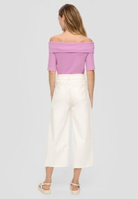 Ružový top bez ramienok s krátkymi rukávmi, kombinovaný s bielymi nohavicami s vysokým pásom a širokými nohavicami, a béžovými sandálmi, s jemnými textúrami a čistými líniami.