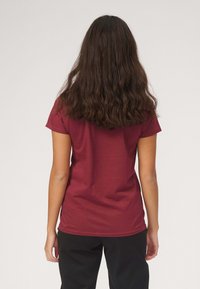 Mørkerød t-shirt med korte ærmer, glat tekstur, tætsiddende design, og rund halsudskæring. Bagfra ses ingen synlig branding eller mønstre.