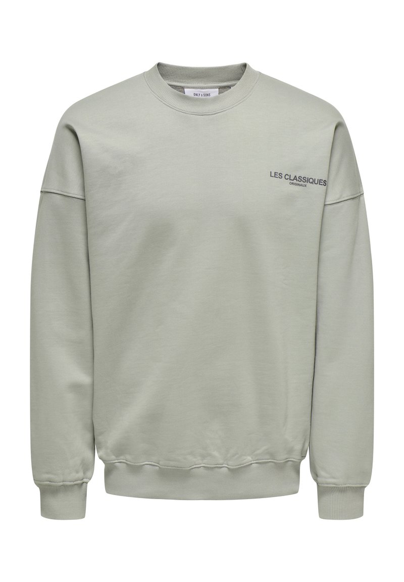 Hellgrau Sweatshirt mit Rundhalsausschnitt, gerippten Bündchen und Saum. Auf der Vorderseite befindet sich ein gedruckter Text „LES CLASSIQUES“ in Dunkelblau.