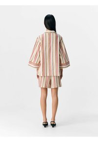 Gestreepte kimono-stijl jas en korte broek set in crème, roze en geel. Lichtgewicht stof met wijde mouwen en een relaxte pasvorm.