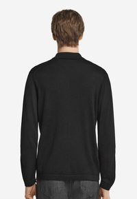 Svart långärmad polo skjorta i mjukt tyg, med standardkrage och rak fåll, utan synliga mönster eller detaljer.