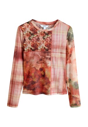 Langærmet bluse med et farverigt patchworkdesign med blomster mønstre og ternede sektioner i nuancer af pink og rød.