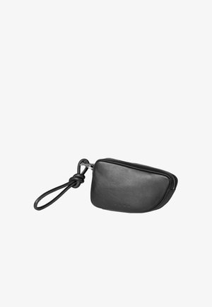 Schwarze Ledertasche mit abgerundeter Form, Reißverschluss und geknotetem Handgelenkriemen. Glatte Textur ohne sichtbare Muster oder metallische Akzente.