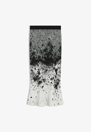 Svart och vit knälång kjol med ett fiskbensmönster i midjan och en gradient av stänkmönster ned mot fållen.