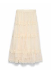 Jupe en tulle superposée de couleur beige clair avec bordure en dentelle. Elle présente une ceinture élastique et un design fluide à plusieurs couches pour plus de mouvement.