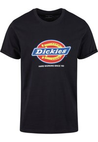 Juodas medvilninis marškinėliai su spalvingu "Dickies" logo raudona, mėlyna ir geltona spalvomis, o apačioje esantis tekstas skelbia "SUNKAUS DARBAS NUO 1922".