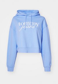 Sudadera recortada de color azul claro con capucha y cordones. Presenta un gran logo en blanco de "tommy jeans". Está hecha de una tela suave con puños de canalé.