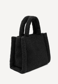 Melna teksturēta lielā soma ar mīkstu ārējo virsmu, izturīgām rokturiem un strukturētu taisnstūra formu ar redzamām šuvēm.