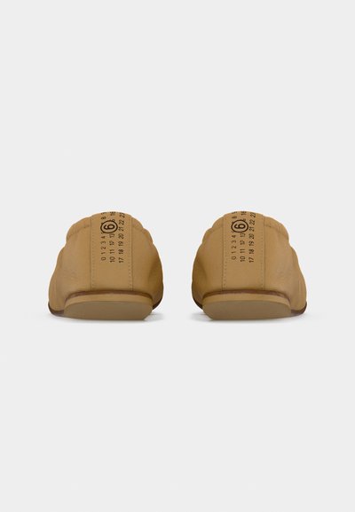 Ζευγάρι καφέ δερμάτινων παπουτσιών χωρίς κορδόνια, που φαίνεται από πίσω, με τυπωμένο το μέγεθος 6 στις ετικέτες της φτέρνας με αριθμητικές ενδείξ εις.