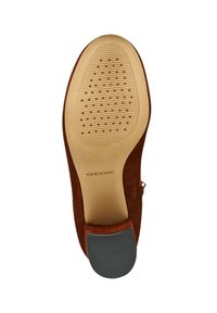 Zapato de ante marrón con suela de goma texturizada, con un talón liso y un logo embosado. La suela tiene ranuras redondeadas para una mejor tracción.