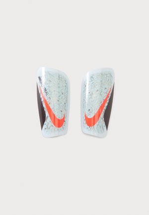 Paire de protège-tibias de football Nike Mercurial avec un motif craquelé bleu clair et blanc et des logos Swoosh orange vif.