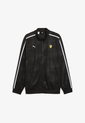 Chaqueta negra Puma con cremallera frontal, franjas blancas en las mangas, logo de Puma en el pecho derecho y escudo amarillo de Ferrari en el pecho izquierdo.