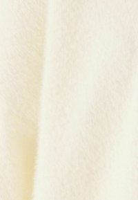 Kołnierzowa tkanina w kolorze kremowym, o miękkiej teksturze; charakteryzuje się delikatnym połyskiem, lekko uniesionymi włóknami i gładką, równą powierzchnią.