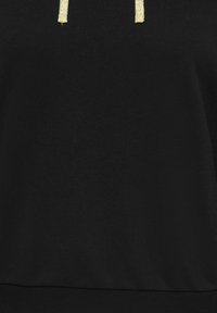 Mustast kapuutsist riie kahe kuldse sädelevate nööriga, mis rippuvad ülaosas keskel.