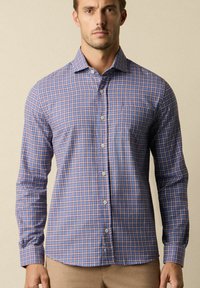 Camicia button-up in un motivo a quadri blu e bianco con dettagli arancioni. Presenta un colletto classico, maniche lunghe e una tasca sul petto.