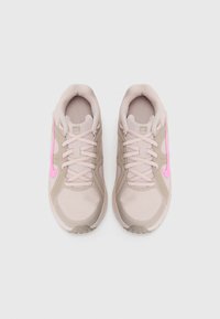 Beige sportovní boty s růžovými akcenty. Mesh horní část, polstrovaný jazyk a texturovaná podrážka pro účinný grip. Obsahují šňůrky a podpůrné překryvy.