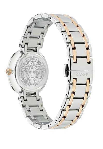 Montre en acier inoxydable avec un bracelet bimatière, comportant des maillons argentés et dorés. Boîtier rond avec un verre saphir et un logo méduse gravé.