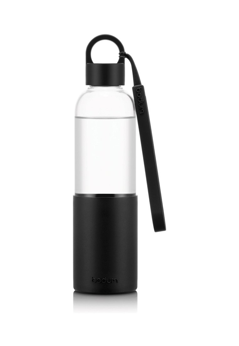 Botella de agua de vidrio transparente con base de silicona negra mate, forma cilíndrica, tapa con asa y logotipo de la marca en el lateral.