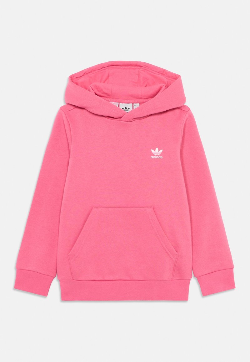 Różowa bluza z kapturem Adidas z przednią kieszenią, długimi rękawami i białym logo Adidas na lewej piersi na jednolitym tle.