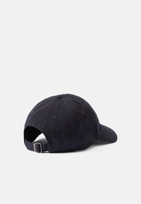 Gorra de béisbol de algodón en azul marino oscuro, con visera curva, ojales bordados, correa trasera ajustable y una textura suave.