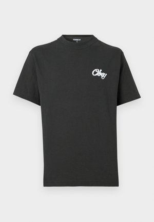 Črna T-majica s kratkimi rokavi in majhnim belim napisom 'Obey' na levi strani prsnega koša, okrogel izrez, velikost srednja, označena znotraj ovratnika.