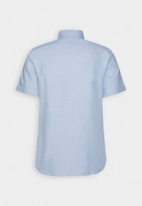 Chemise bleu clair à manches courtes avec un col classique, vue de dos sur un fond blanc uni.