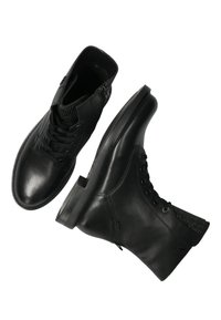 Czarne skórzane botki za kostkę z teksturowaną cholewką, wiązaniem z przodu i zamkiem błyskawicznym z boku. Posiadają solidną gumową podeszwę i minimalistyczny design.