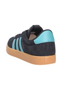 Čierne semišové tenisky s tyrkysovými akcentmi, tromi bočnými pruhmi a gumovou podrážkou. Disponujú polstrovaným golierom a textúrovaným zvrškom.