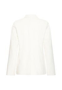 Blazer blanc à manches longues, col cranté et coupe structurée. Texture lisse avec des lignes épurées et sans fermetures visibles.