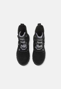 Bottines en suédine noire avec doublure en tissu gris, dotées de lacets noirs et d'une semelle en caoutchouc texturée. Conçues pour la durabilité et le confort.