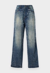 Jeans en denim bleu foncé avec des zones décolorées et des clous carrés en argent symétriques couvrant les jambes avant de la taille à l'ourlet.