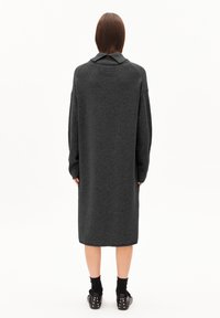 Robe pull oversized gris foncé avec un col, des manches longues et des détails côtelés ; texture lisse et design à hauteur du genou.