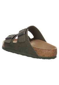 Green, contoured slip-on sandal with two adjustable straps, cork footbed, and textured material. Soft inner lining and sturdy sole.