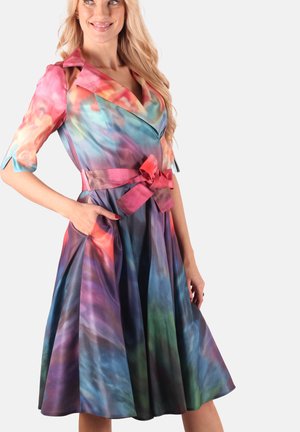 Bunt gemustertes, knielanges Kleid mit Wasserfallkragen, tailliertem Bund in Pink und abstrakten Mustern in Blau-, Lila- und Rottönen.