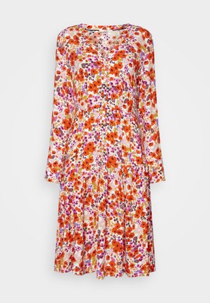 Vestido floral de manga larga, con una mezcla de flores rojas, naranjas y moradas sobre un fondo blanco. Con una longitud hasta la rodilla, corte suelto y escote en V.