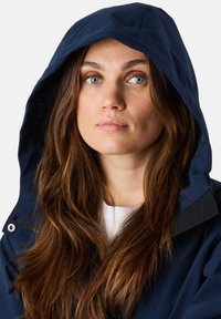 Giacca impermeabile blu navy con cappuccio, dotata di chiusura a zip e tasche laterali. Tessuto liscio con una finitura leggera e durevole.