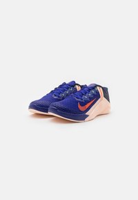 Scarpe da corsa in rete blu con accenti arancioni, suola testurizzata, design leggero e lacci multicolori. Tallone rinforzato e parte superiore traspirante.