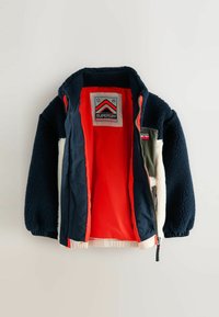 Námornícko modrá fleecová bunda s krémovými detailami, jasne oranžovým podšívaním, plným zipsom a logom Superdry Mountain Sport na vnútornej strane goliera.