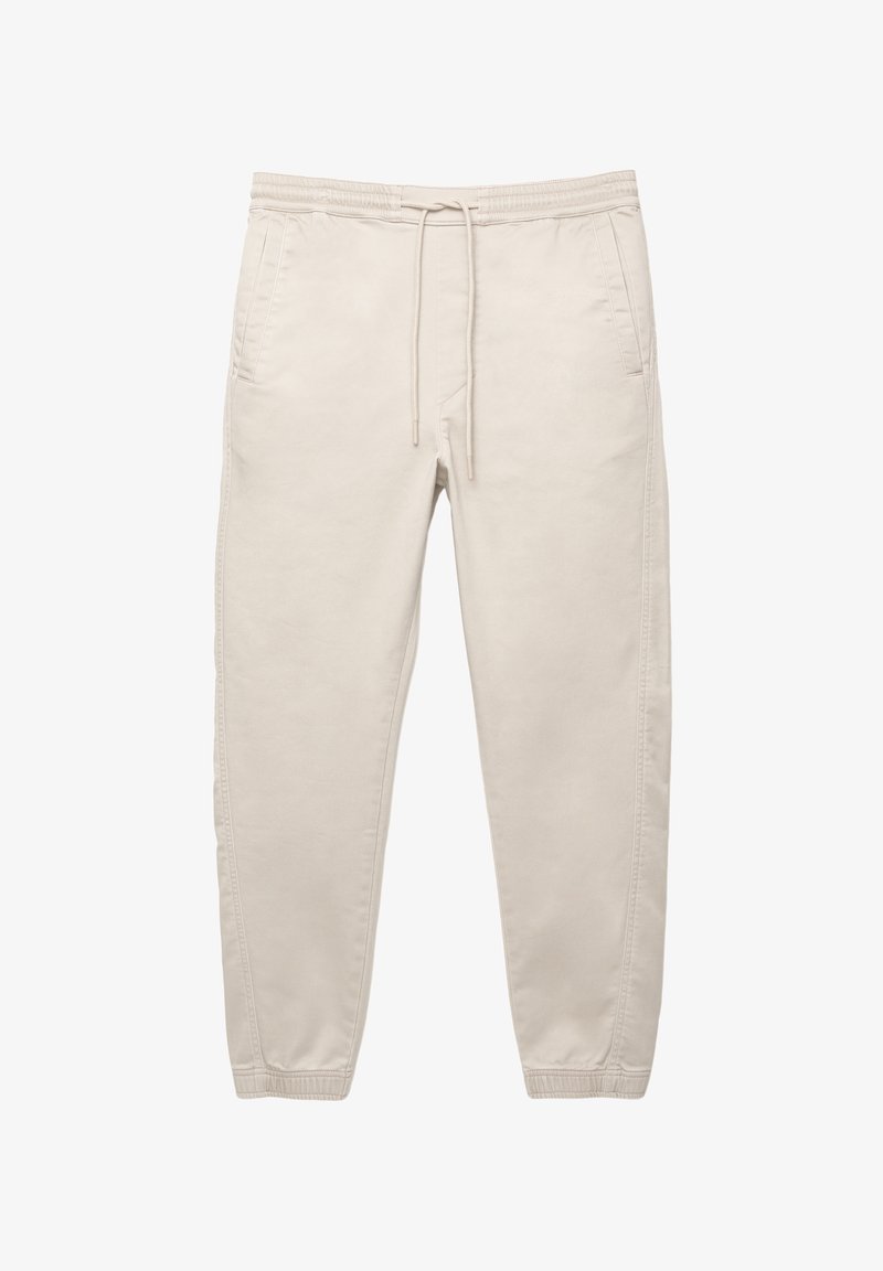 Beiga bomullbyxor med elastisk midja, dragsko, sidofickor och avsmalnande ben. Slät textur och minimalistisk design.