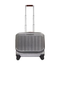 Zilverkleurige harde koffer met verticale ribbels, telescopisch handvat en vier wielen voor mobiliteit; voorzien van een bruine lederen accenten op het handvat.