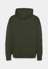Tmavě zelená mikina s kapucí na šňůrku, pružnými manžetami a lemem, vyrobená z měkké texturované látky. Design se vyznačuje uvolněným střihem.