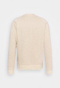 Pull beige à manches longues avec une fine texture côtelée horizontale et des poignets et un ourlet lisses, montré de dos sur un fond clair.